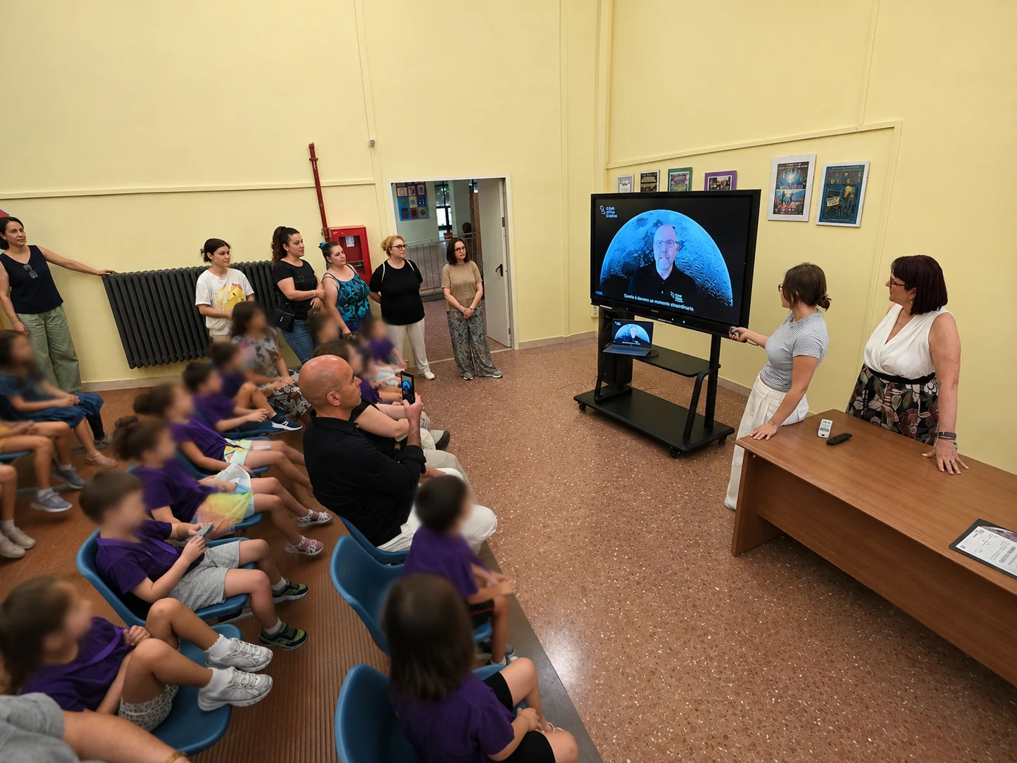 Moonshot in school, Rome, 30 June 2026. Bryan DeBates from CSH is talking on the screen.